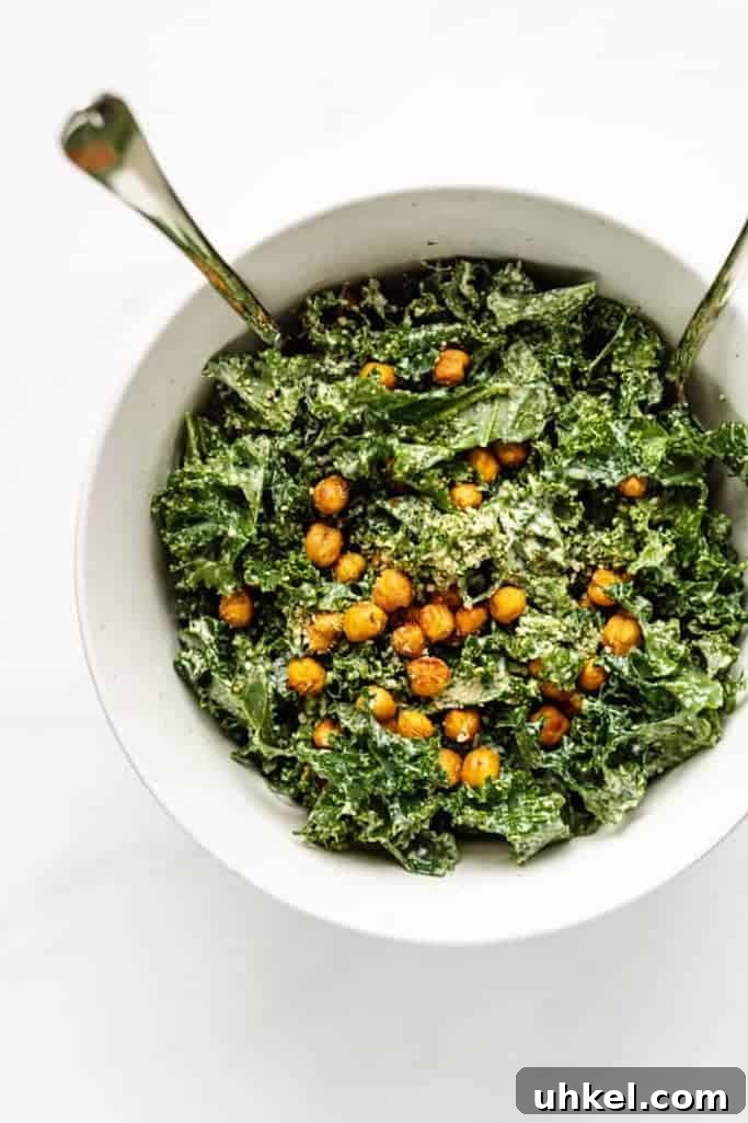 freshly chopped kale covered with smokey roasted chickpeas in a white bowl on a white marble countertop, summer salads with kale 