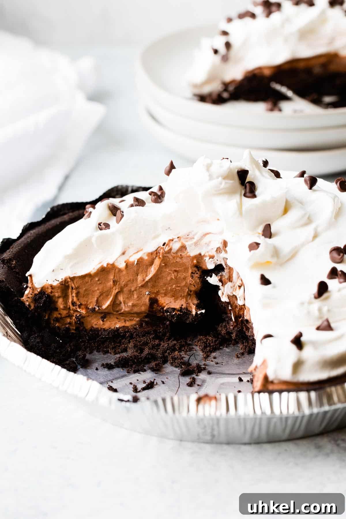 No-Bake Chocolate Pudding Pie with Cool Whip and Jell-O 2 a chocolate pie topped with whipped cream with a slice taken out and set in background