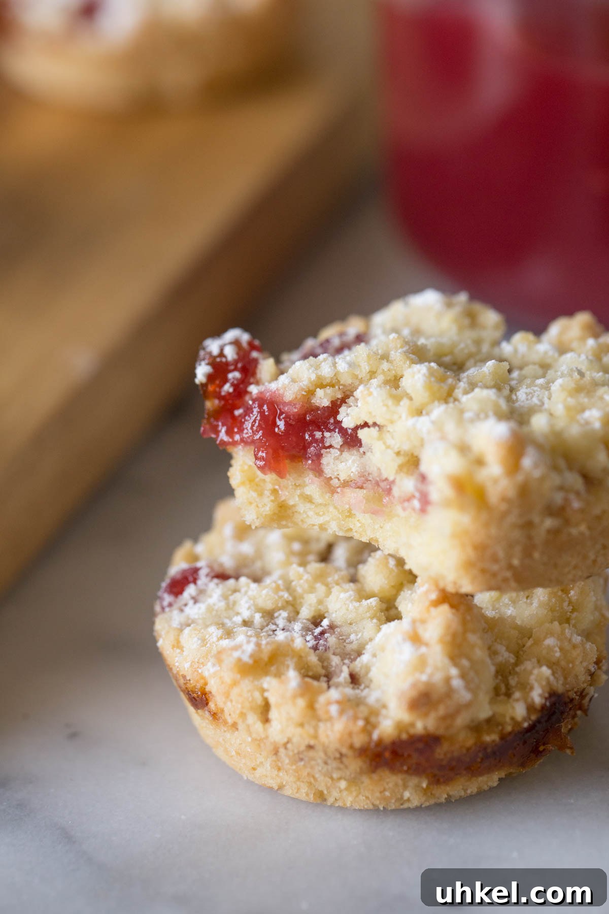 Costco Raspberry Crumble Cookies Review & Where to Buy 5 Close up shot of two Costco Raspberry Crumble Cookies, one with a bite missing, showing the inside texture of the cookie.