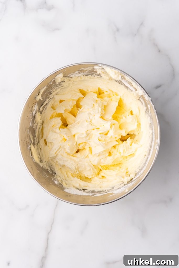 Champagne-Infused Cupcakes: Sparkling Celebration Recipe 8 fluffy white buttercream frosting in a metal mixing bowl
