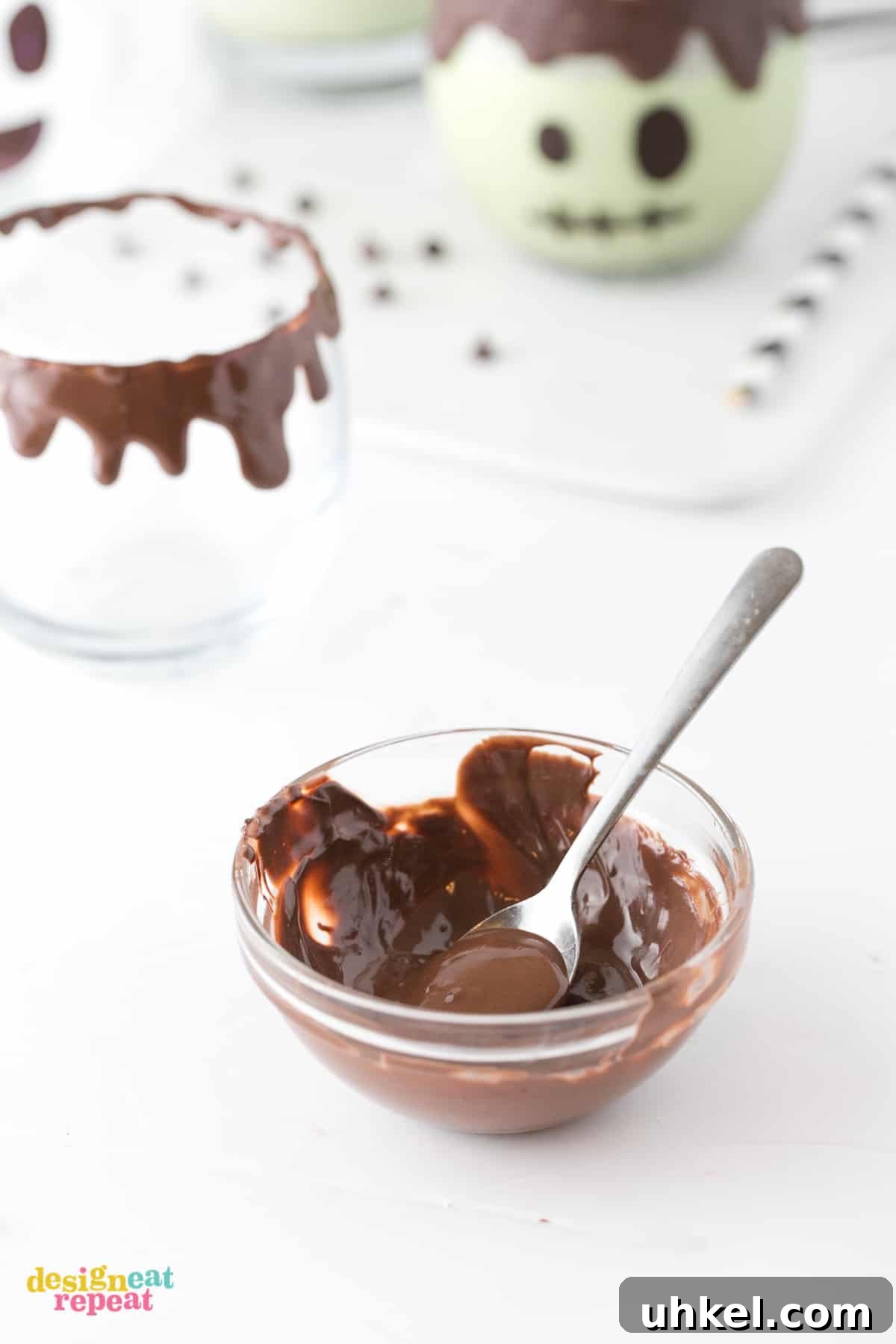 Frankenstein Halloween Milkshakes: Green Monster Dessert Recipe 4 Bowl of melted dark chocolate with small spoon piping on rim of glass. Frankenstein Halloween Milkshakes