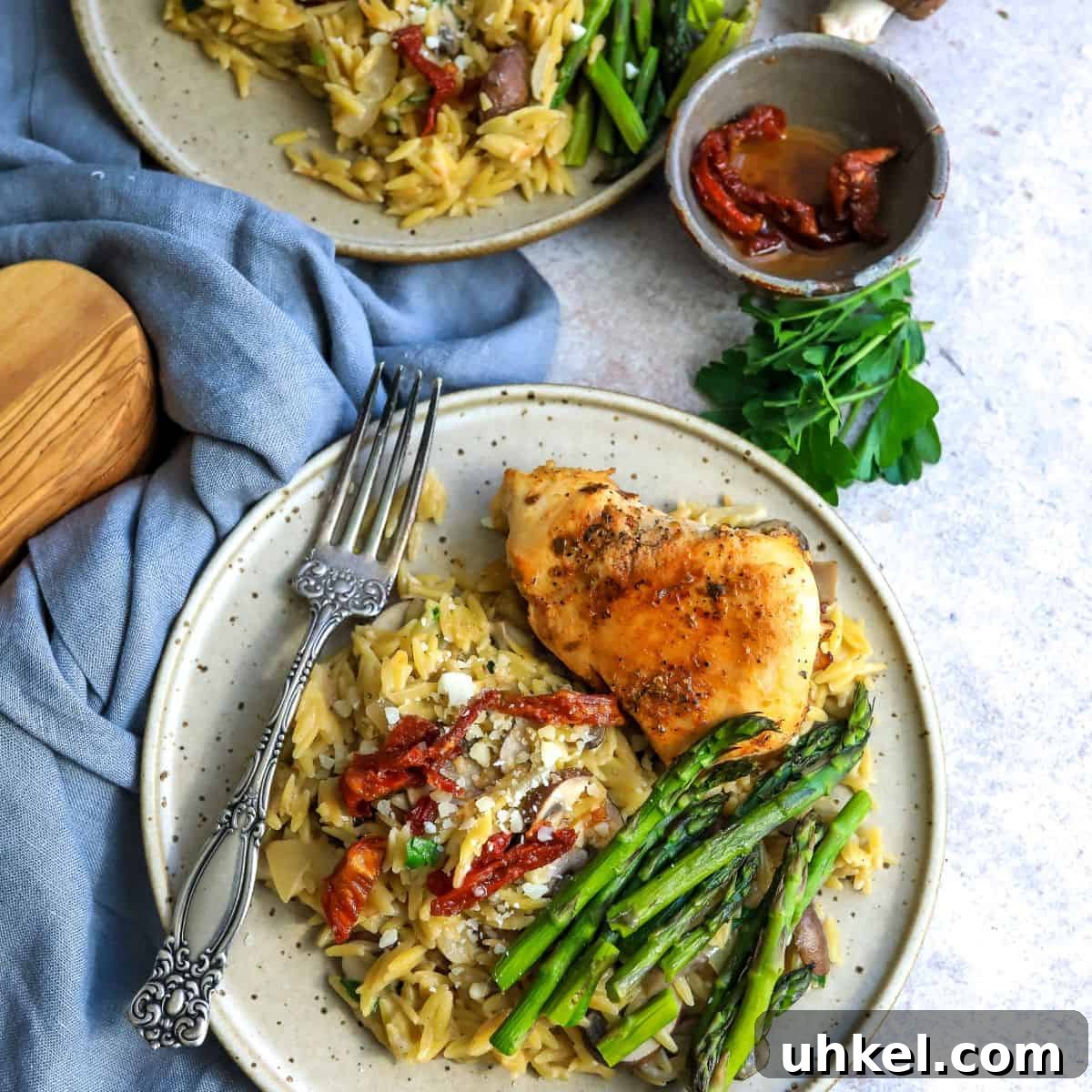 Creamy Garlic Parmesan Chicken Orzo Recipe 7 Two plates with creamy orzo and asparagus.
