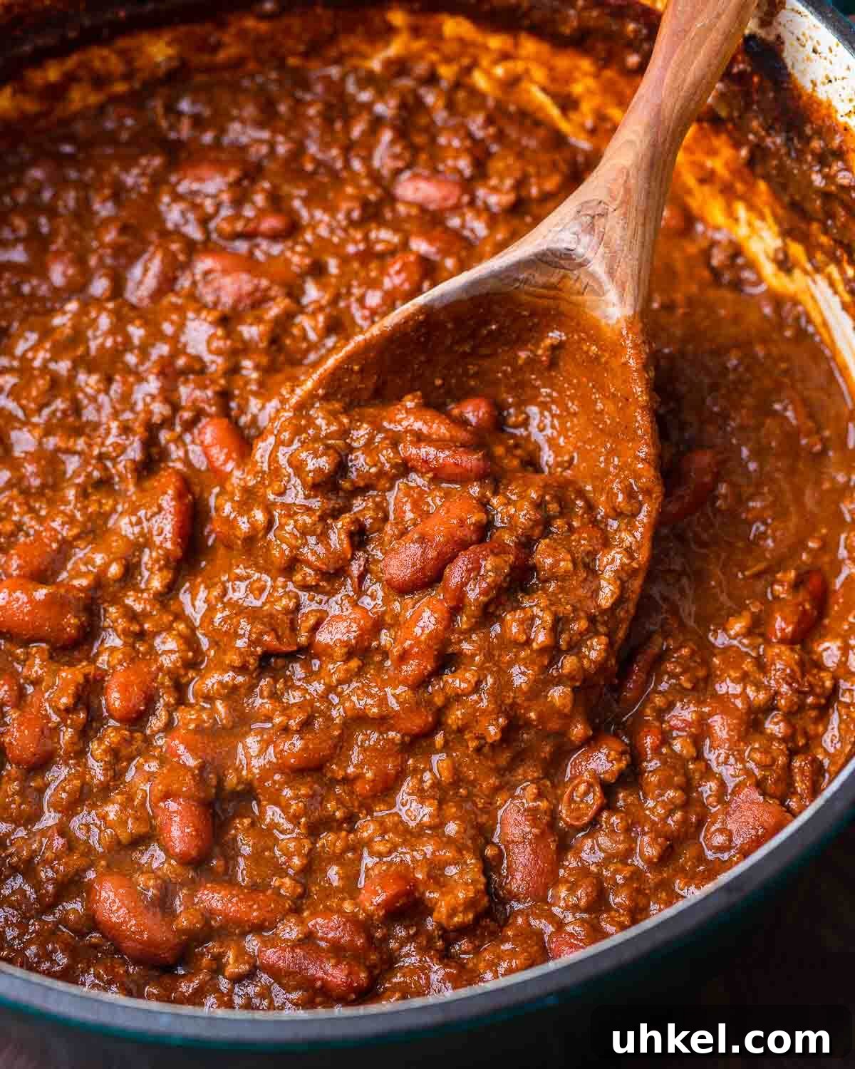 Authentic Classic Chili Recipe for Hearty Weeknight Dinners 4 Large Dutch oven with classic chili and large wooden ladle.