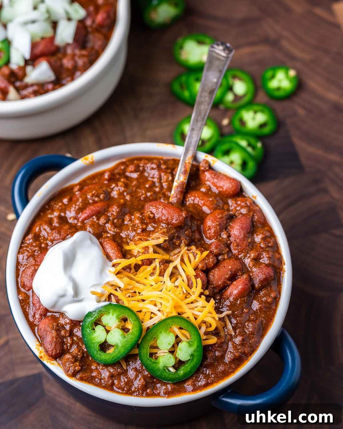 Authentic Classic Chili Recipe for Hearty Weeknight Dinners 5 Bowl of chili topped with jalapeno, cheddar cheese, and sour cream.