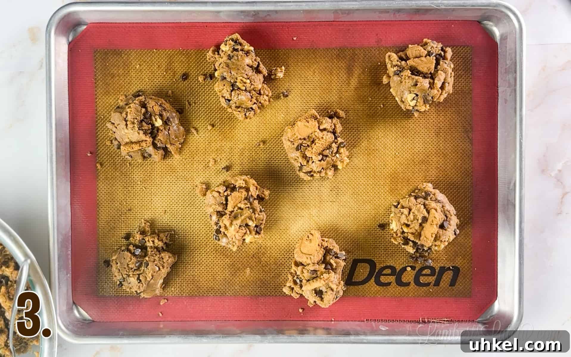 Loaded Cookie Butter Cookies — Gooey Speculoos-Stuffed Treats 6 cookie butter cookie dough on a baking sheet.