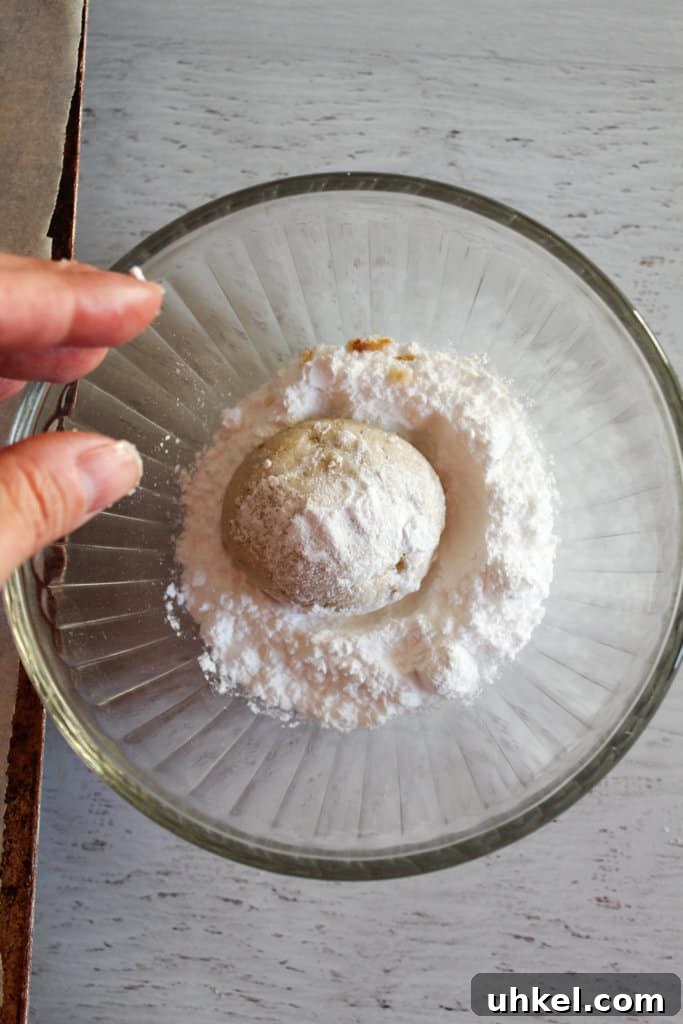 Gluten-Free Mexican Wedding Cookies — Simple, Delicious Recipe 7 hand rolling cookies in powdered sugar.