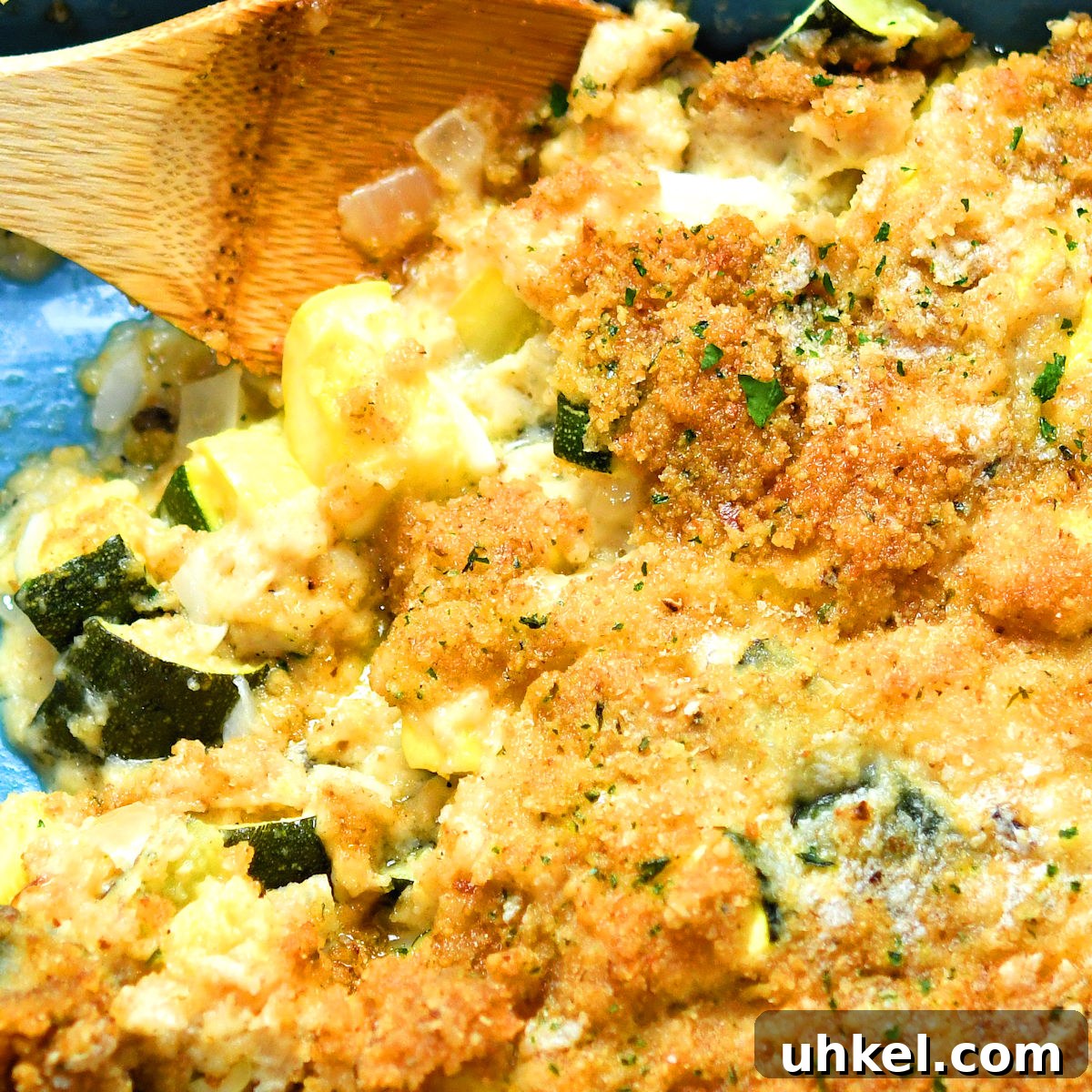Cheesy Zucchini and Summer Squash Casserole Recipe 9 extreme closeup of zucchini casserole in a blue ceramic baking dish