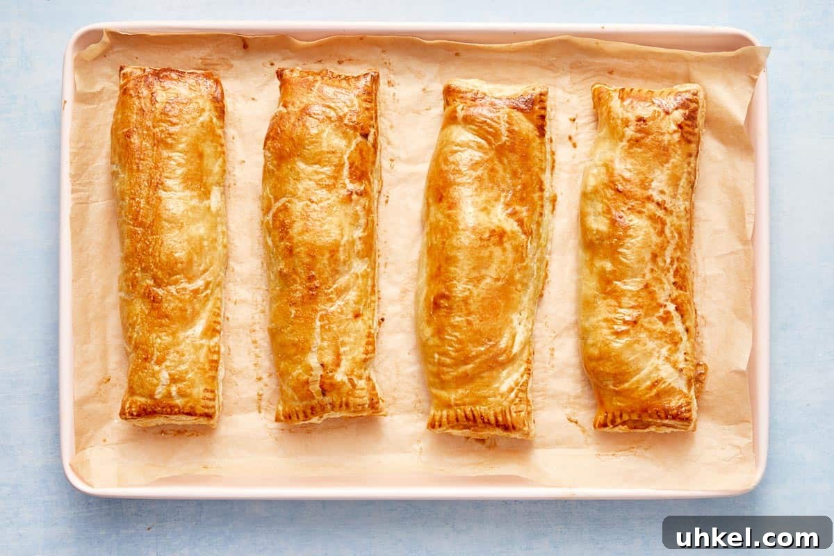 Freshly baked golden salmon parcels on a tray, straight from the oven.