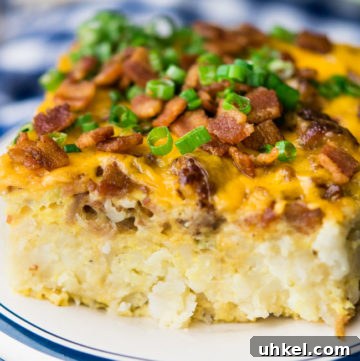 Cheesy Tater Tot Breakfast Casserole with Sausage and Veggies 3 tater tot breakfast casserole on a plate, topped chopped with green onions and bacon