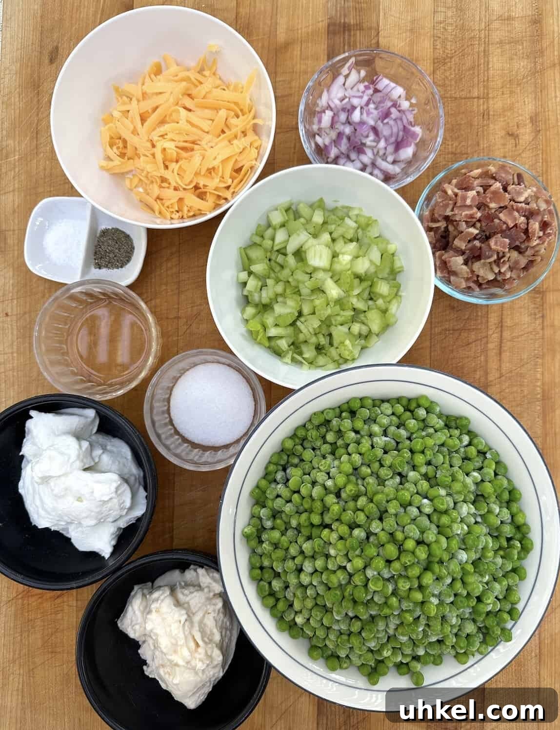 Creamy English Pea Salad with Bacon and Mint 3 Ingredients for pea salad in bowls and arranged on a cutting board.