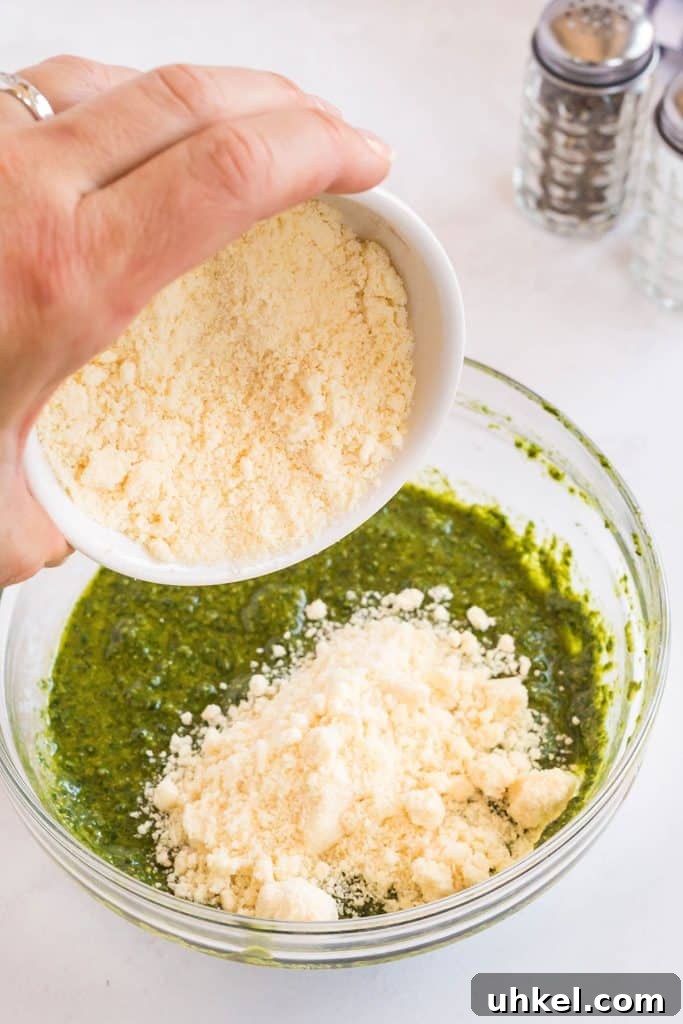 Classic Basil Pesto Recipe: Fresh, Vibrant Sauce for Pasta & More 10 pouring parmesan cheese into a bowl with pesto sauce