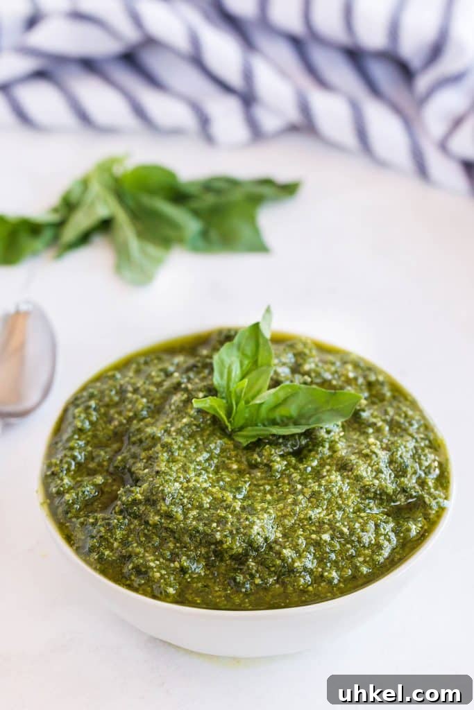 Classic Basil Pesto Recipe: Fresh, Vibrant Sauce for Pasta & More 3 A white bowl filled with pesto made from scratch.
