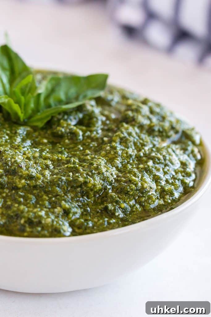 Classic Basil Pesto Recipe: Fresh, Vibrant Sauce for Pasta & More 5 Close up of a white bowl filled with Italian pesto.