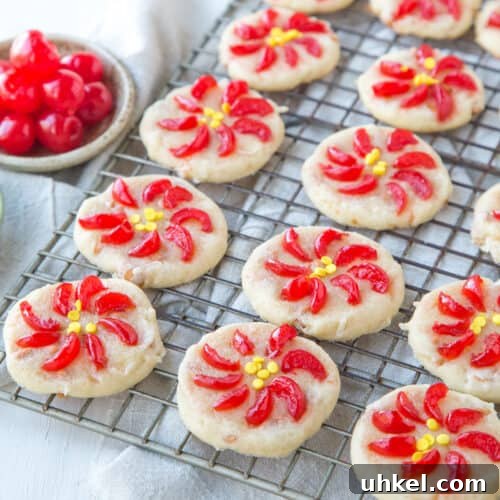 poinsettia cookies made with maraschino cherries on a wire rack.
