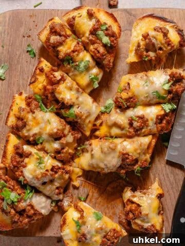 cut garlic bread topped with sloppy joe meat and melted cheese.