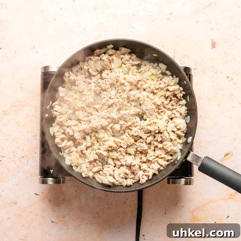 Ground Turkey-Style Sloppy Joes with Ground Chicken 4 ground chicken and onion cooking in a pan.