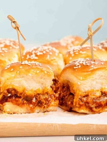 sloppy joe sliders with wooden toothpicks on cutting board.