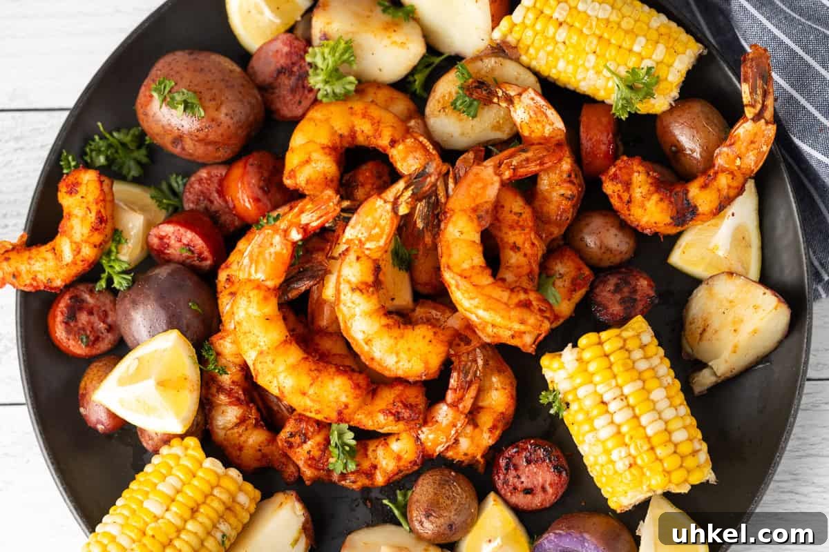 Smoked Shrimp Recipes: How to Smoke Shrimp Perfectly 11 A dozen shrimp on a black platter surrounded with corn, potatoes, and sliced lemons.