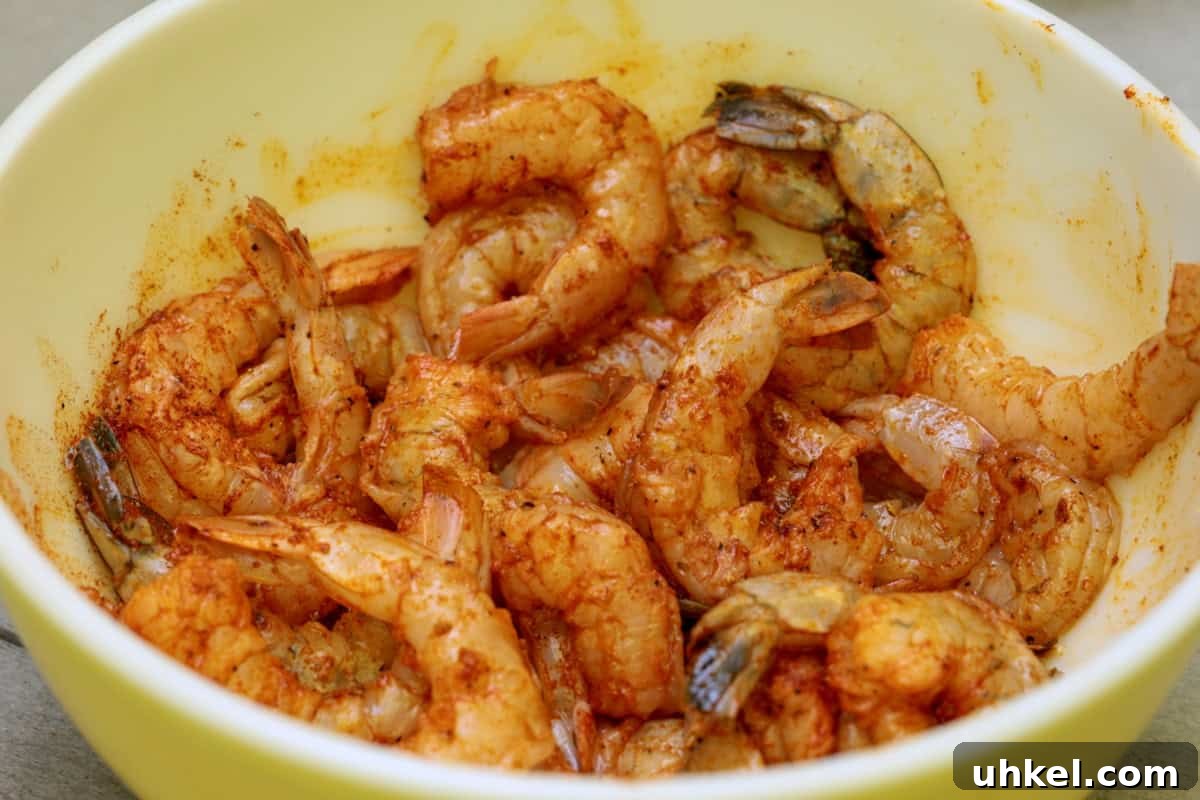 Smoked Shrimp Recipes: How to Smoke Shrimp Perfectly 7 Two dozen shrimp seasoned and marinating in a bowl.