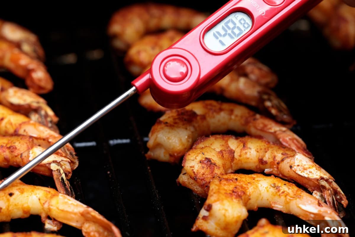 Smoked Shrimp Recipes: How to Smoke Shrimp Perfectly 10 Checking the temperature of shrimp on a grill with a meat thermometer.