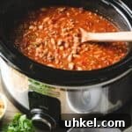 Chipotle Chicken Chili in a crock pot with wooden spoon