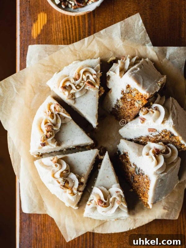 Moist Chocolate Chiffon Cake Recipe for Light, Fluffy Dessert 13 Overhead image of single layer carrot cake frosted on parchment paper and placed on a wood dining room table.