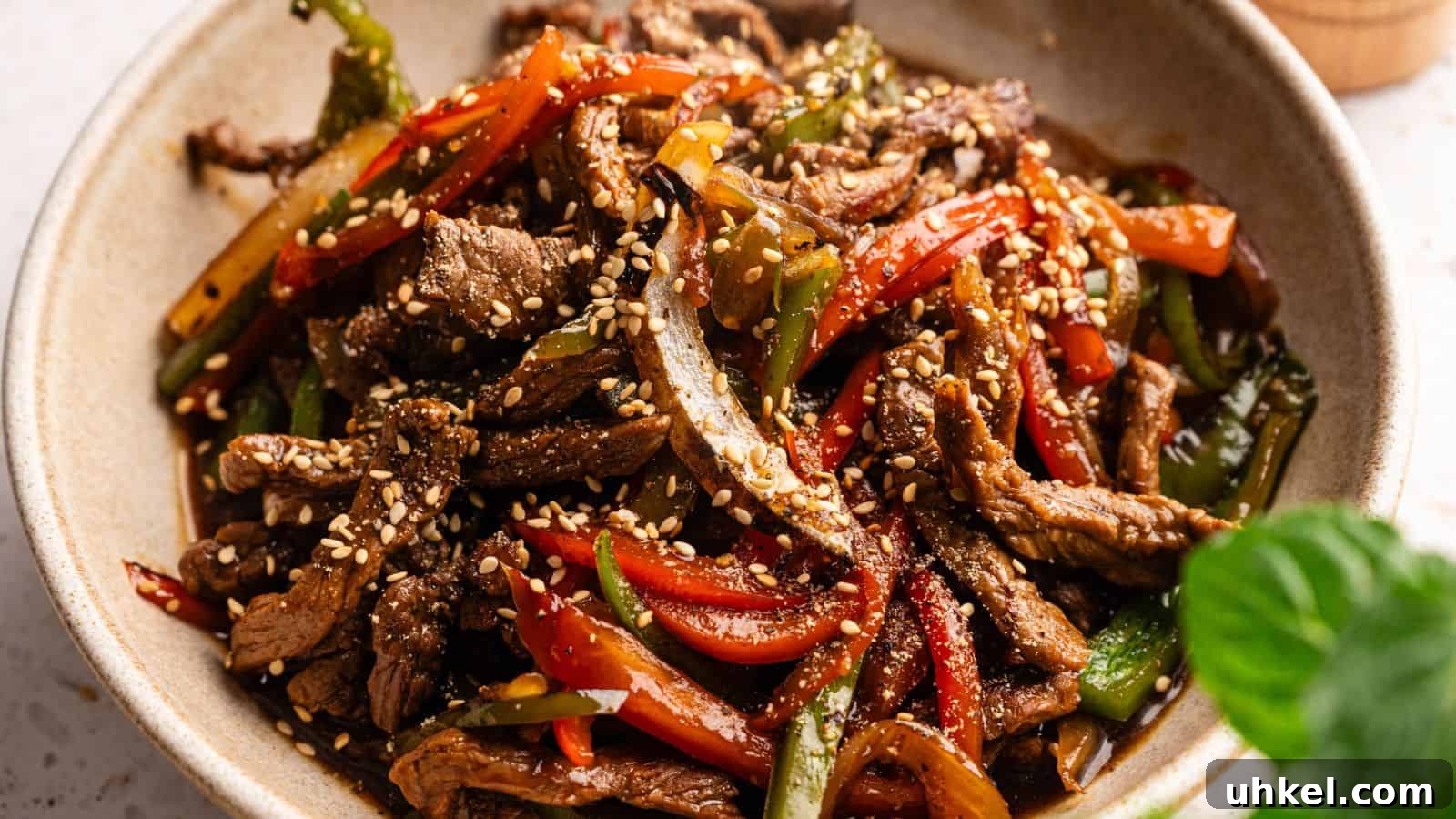 23 Spring Dinner Recipes to Lighten Up Heavy Weeknight Meals 15 A bowl of stir-fried beef strips with red and green bell peppers, topped with sesame seeds.