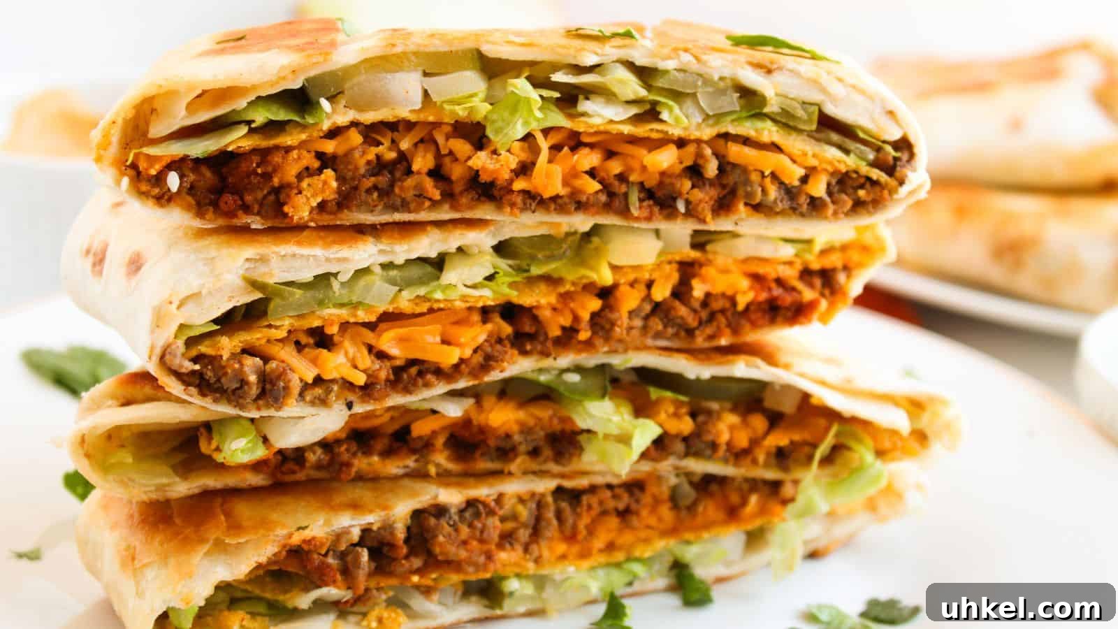 23 Spring Dinner Recipes to Lighten Up Heavy Weeknight Meals 17 Close-up of a stack of folded tortillas filled with beef, melted cheese, lettuce, and onions on a white plate.