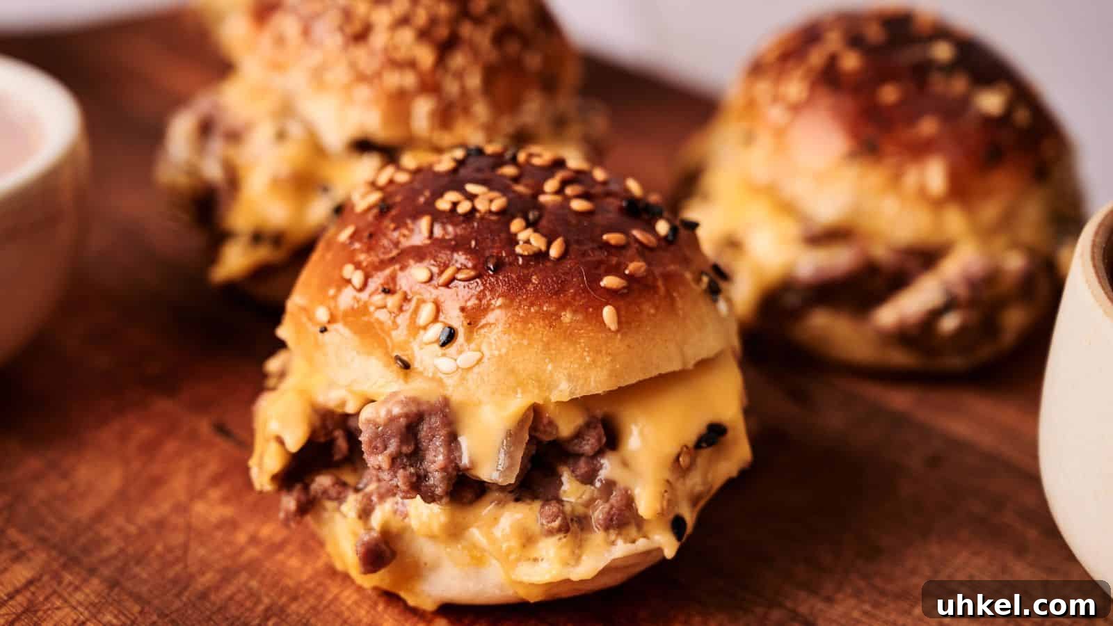 23 Spring Dinner Recipes to Lighten Up Heavy Weeknight Meals 3 Three sesame seed buns filled with melted cheese and ground beef are arranged on a wooden board.