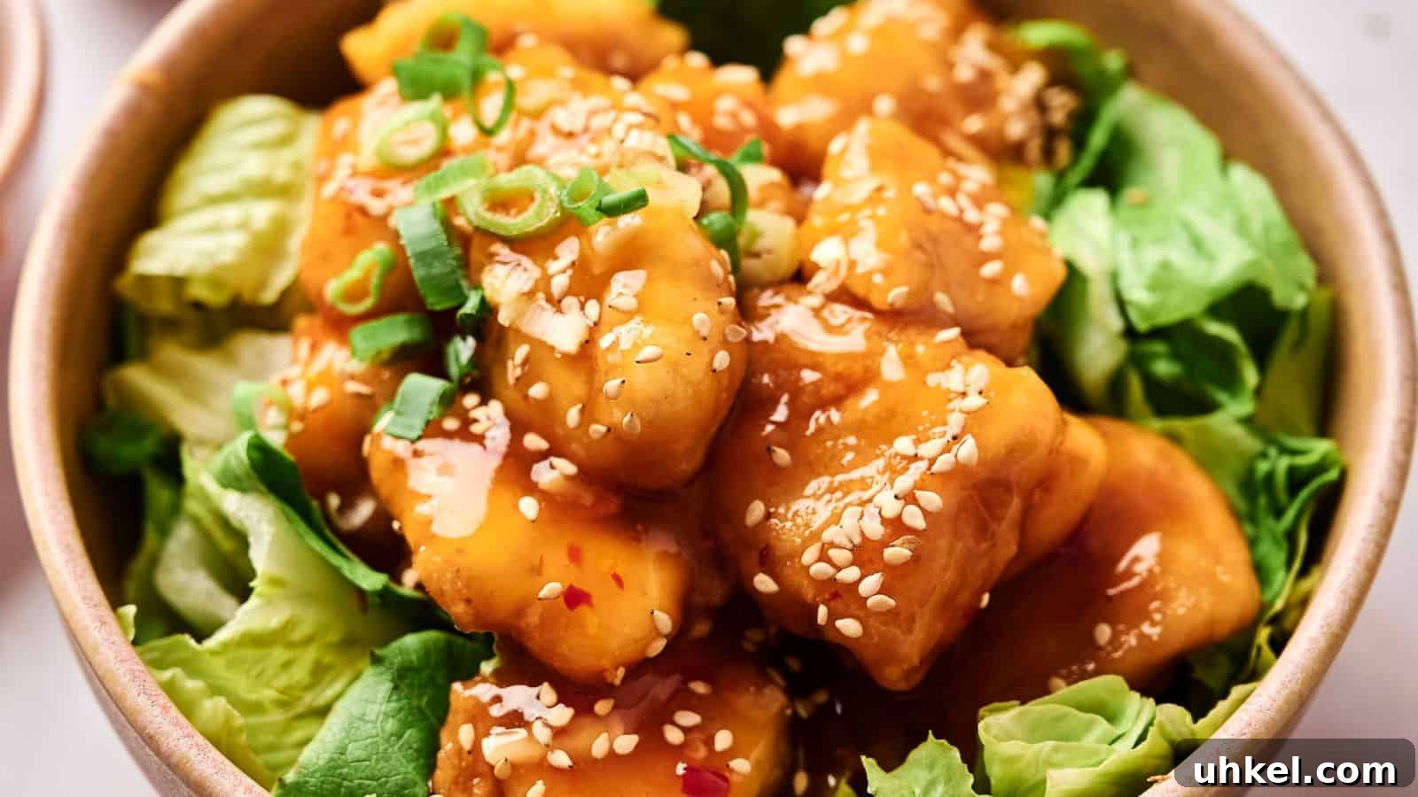 23 Spring Dinner Recipes to Lighten Up Heavy Weeknight Meals 22 A bowl of crispy tofu coated in sesame sauce, garnished with green onions and sesame seeds, served on a bed of lettuce.