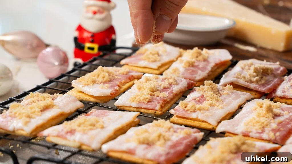 Candied Bacon Crackers: Sweet and Salty Holiday Snack Recipe 3 Candied bacon crackers with parmesan and brown sugar sitting on a baking sheet waiting for the oven.