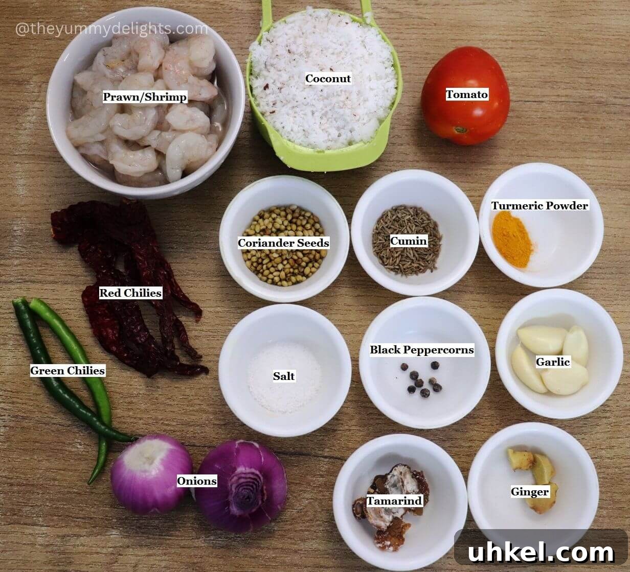 individually labeled ingredients to make goan prawn curry are laid out on a table.