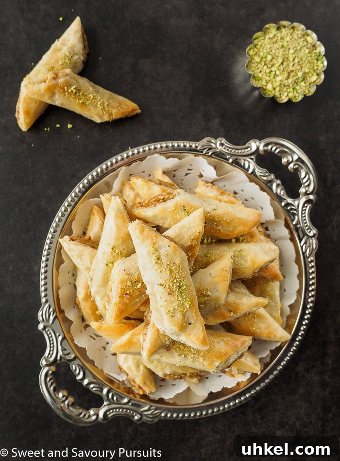 Rolled Baklava fingers piled on serving dish.