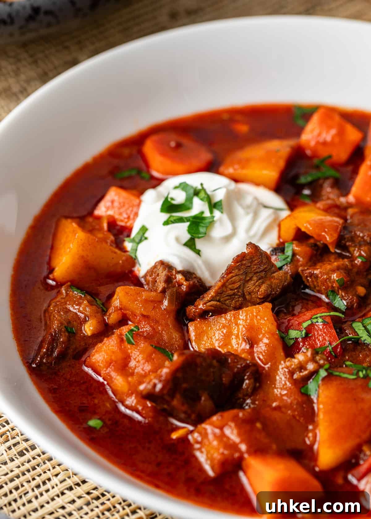 Traditional Hungarian Goulash Recipe: Hearty Beef Stew Guide 12 extreme closeup: hungarian goulash in a bowl with sour creamw, beef, and vegetables showing