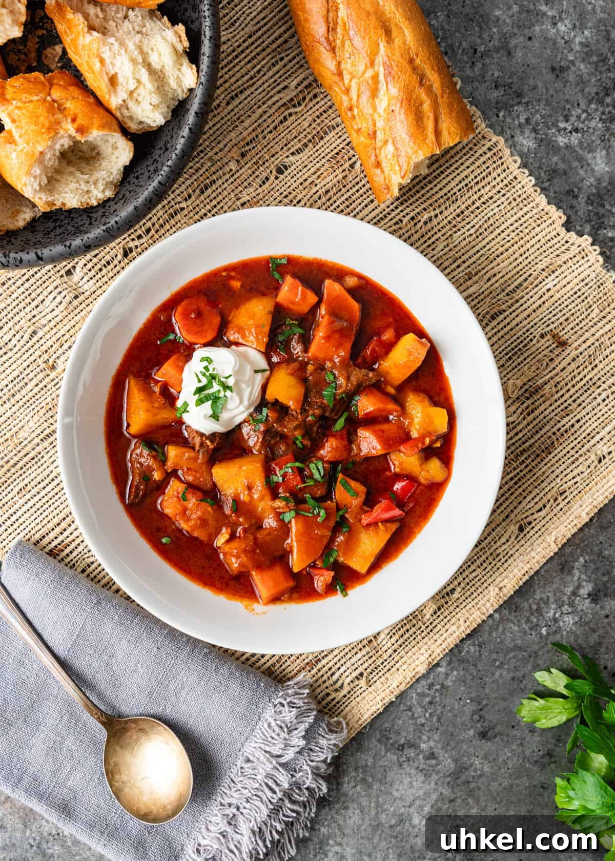 Traditional Hungarian Goulash Recipe: Hearty Beef Stew Guide 3 overhead: my hungarian goulash recipe with a dollop of sour cream on top and baguette on the side