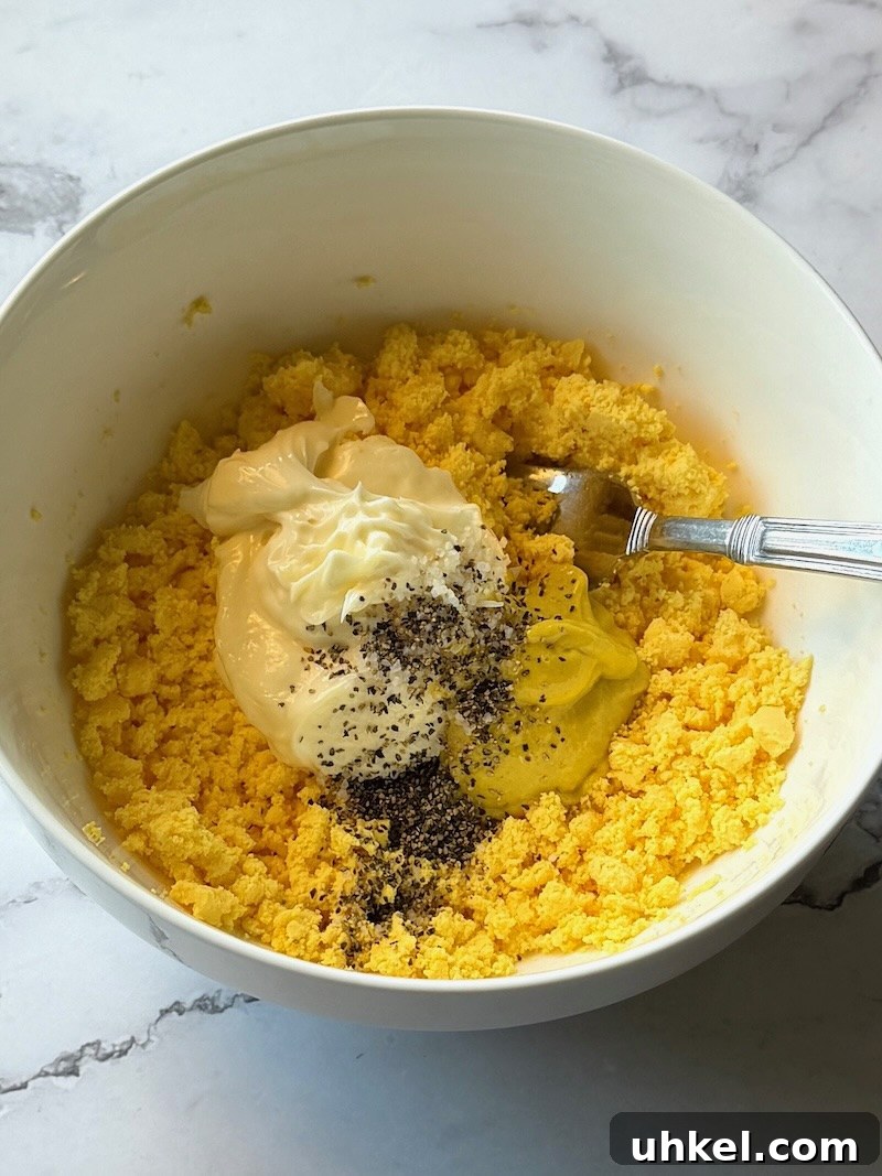 Classic Deviled Eggs Recipe for Gatherings 11 Mayo, mustard, and black pepper added to the smashed egg yolks