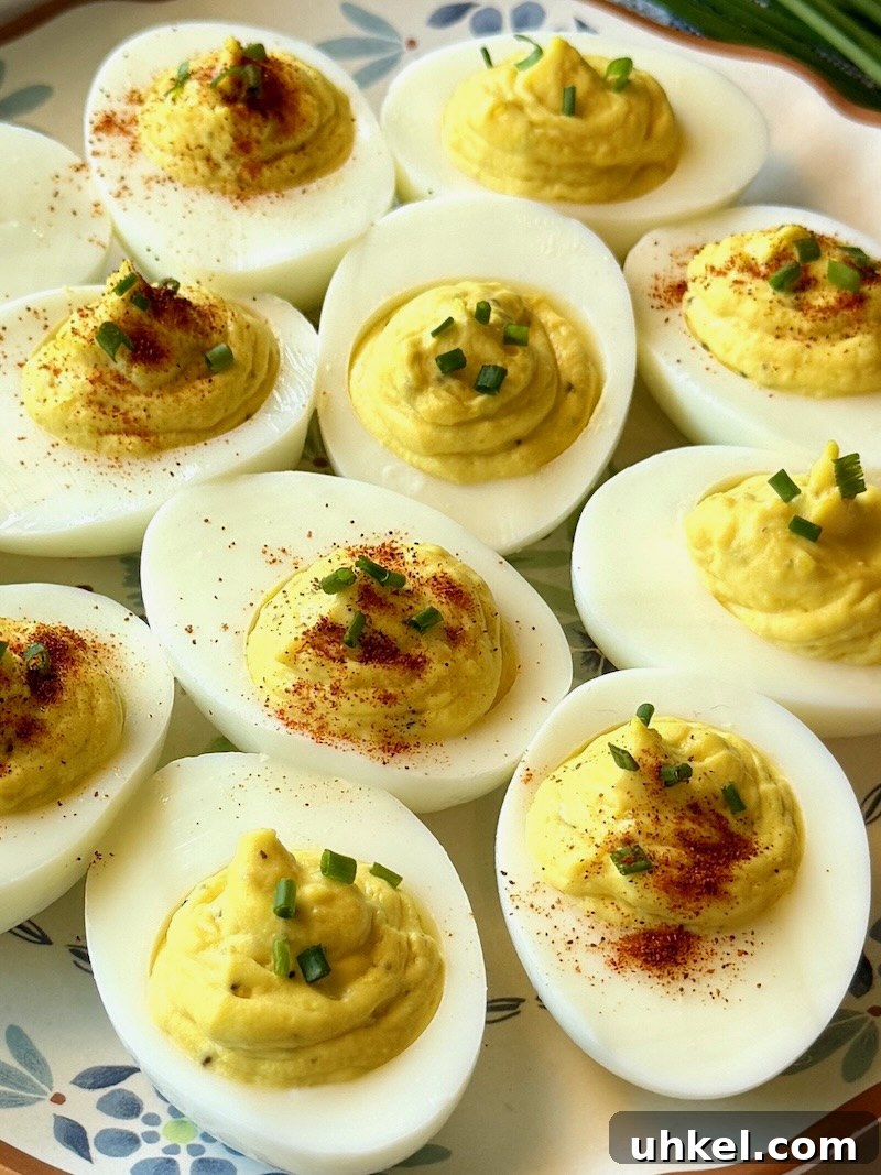 Classic Deviled Eggs Recipe for Gatherings 16 Easy classic deviled eggs prepared on a plate with chives and paprika