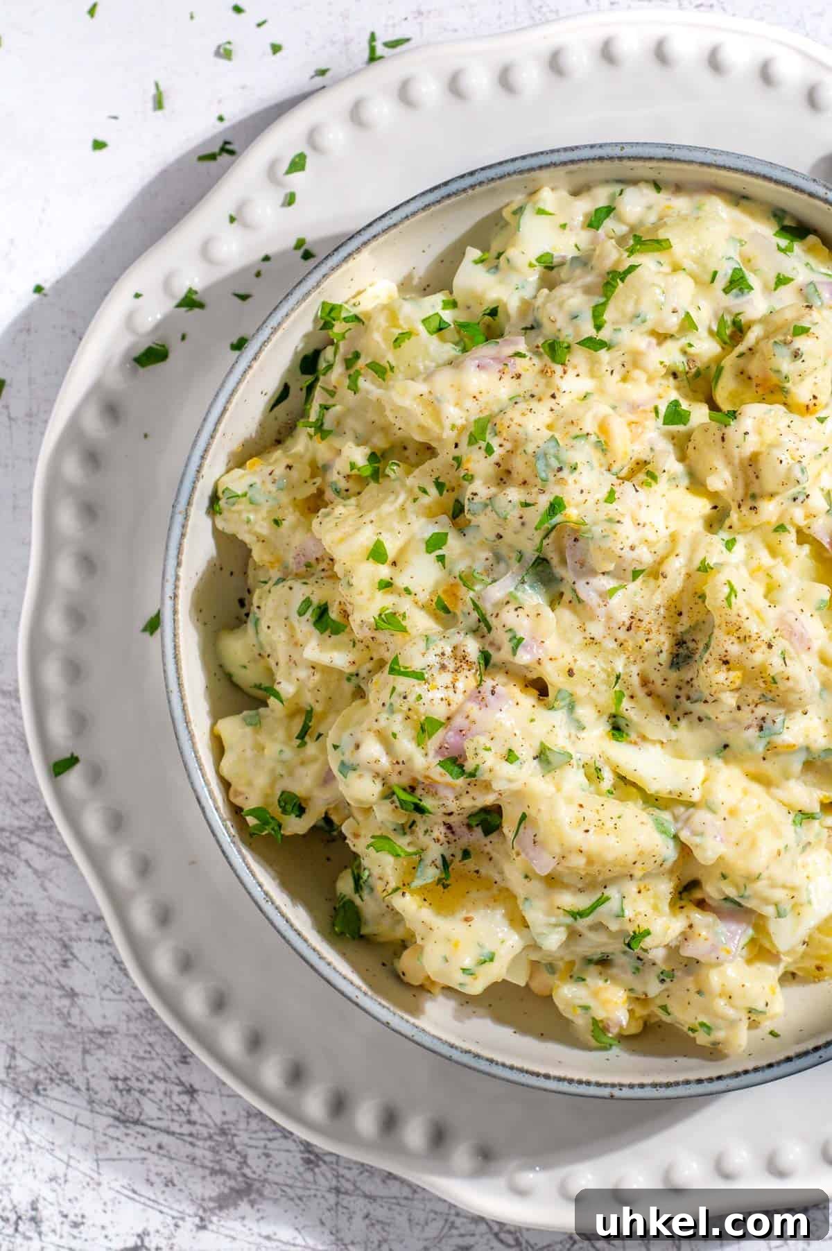 Creamy Potato Salad with Sweetened Condensed Milk Recipe 2 South African potato salad with condensed milk on a white bowl.