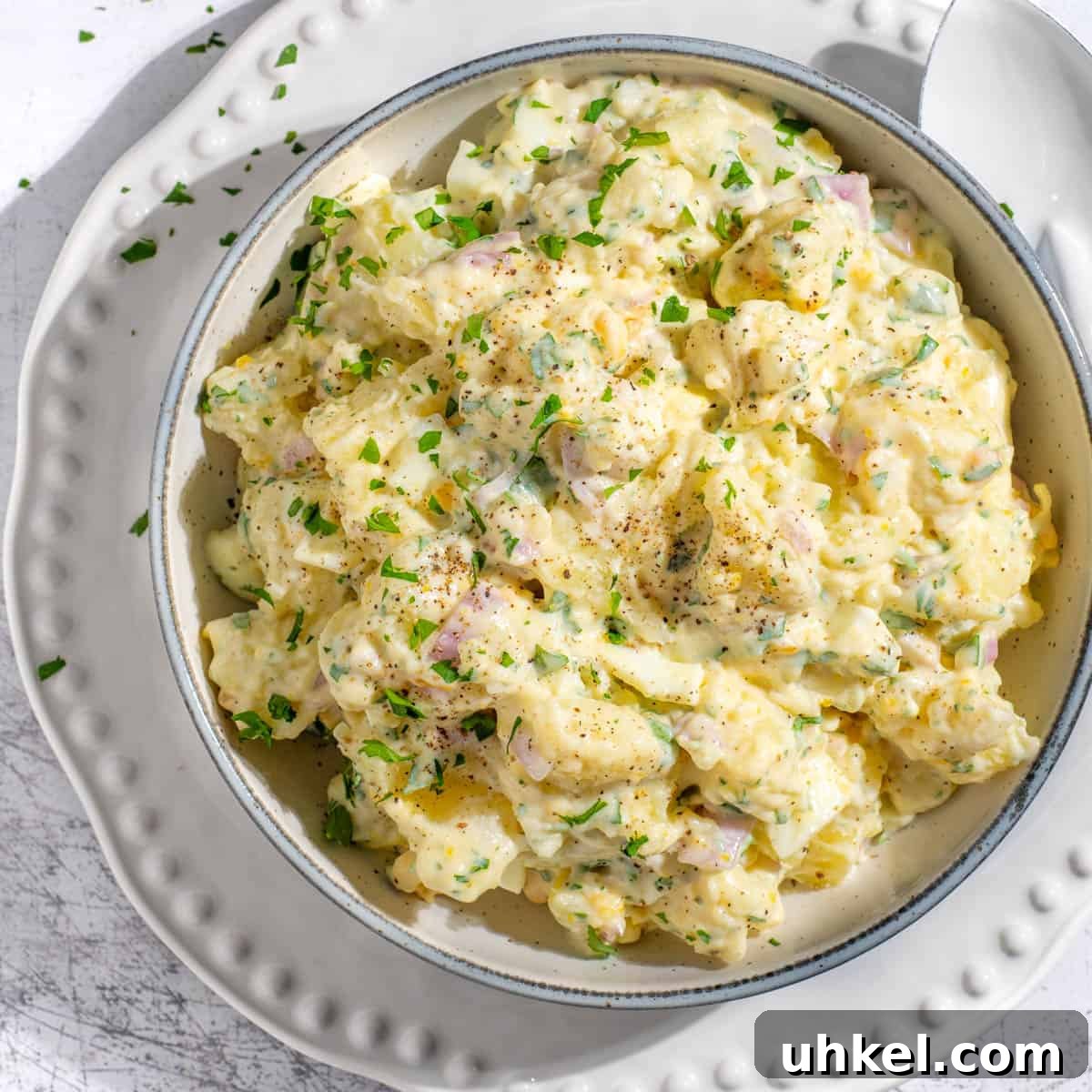 Creamy Potato Salad with Sweetened Condensed Milk Recipe 9 South African potato salad with condensed milk on a white bowl.