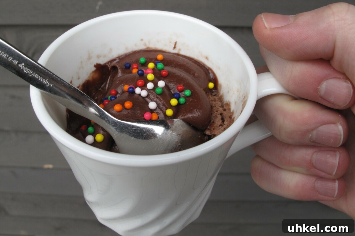 Quick Mug Cake from Cake Mix in 2 Minutes 4 A hand holding a mug of cake