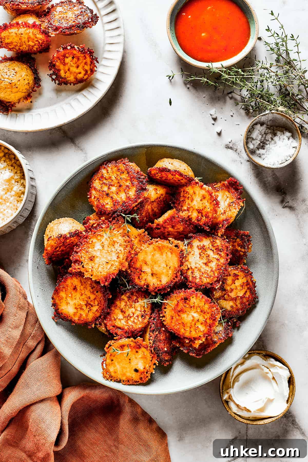 These tender potatoes with a crunchy, cheesy crust are the easiest, tastiest side dish you'll ever make. A viral TikTok recipe you'll love! A bowl of baked potato halves crusted with parmesan cheese.