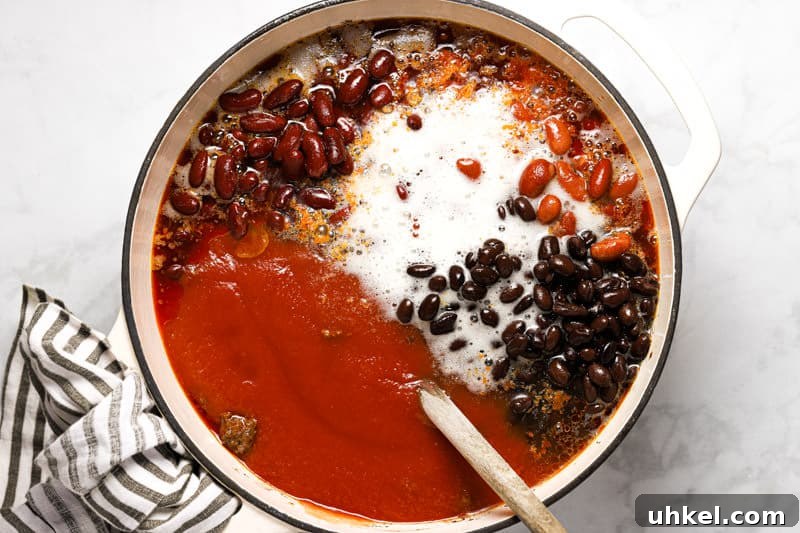 Large white pot filled with ingredients to make beef and beer chili