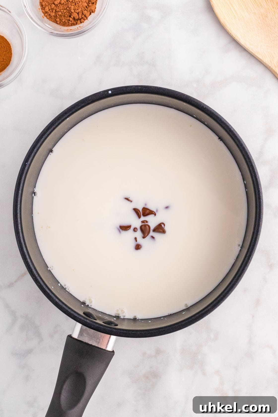 Authentic Mexican Hot Chocolate Recipe – Rich, Spiced Cocoa 6 A pan with milk and chocolate chips in it.
