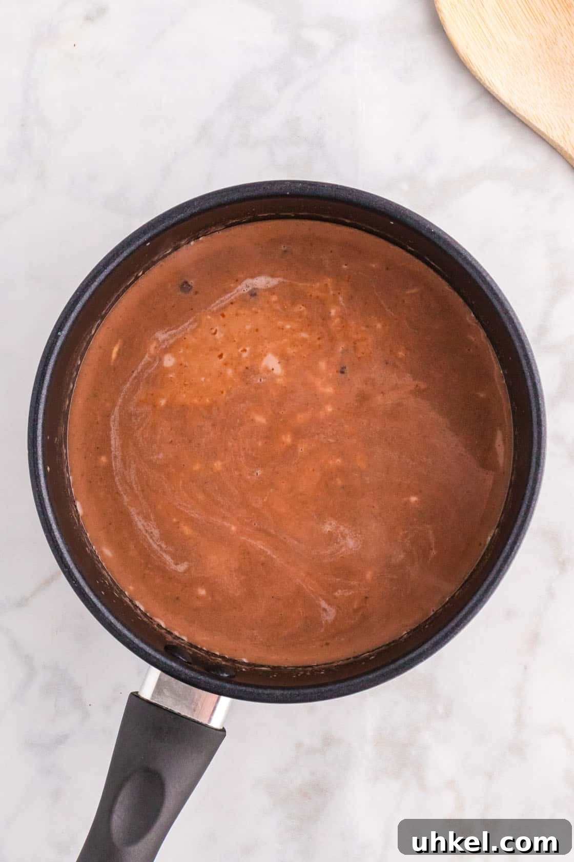 Authentic Mexican Hot Chocolate Recipe – Rich, Spiced Cocoa 8 Cocoa powder, milk, and chocolate chips mixed together in a pan.
