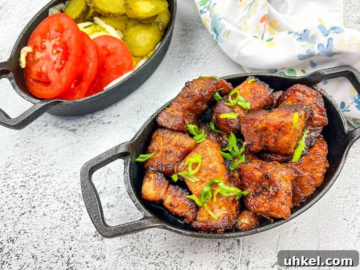 35 Timeless Southern Recipes That Always Delight 22 A plate of smoked pork belly burnt ends with tomatoes and pickles.