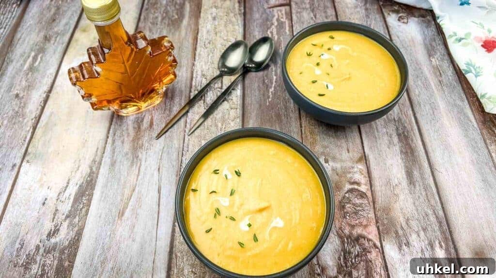 35 Timeless Southern Recipes That Always Delight 6 Two bowls of cream of butternut squash & sweet potato soup garnished with herbs on a wooden table.