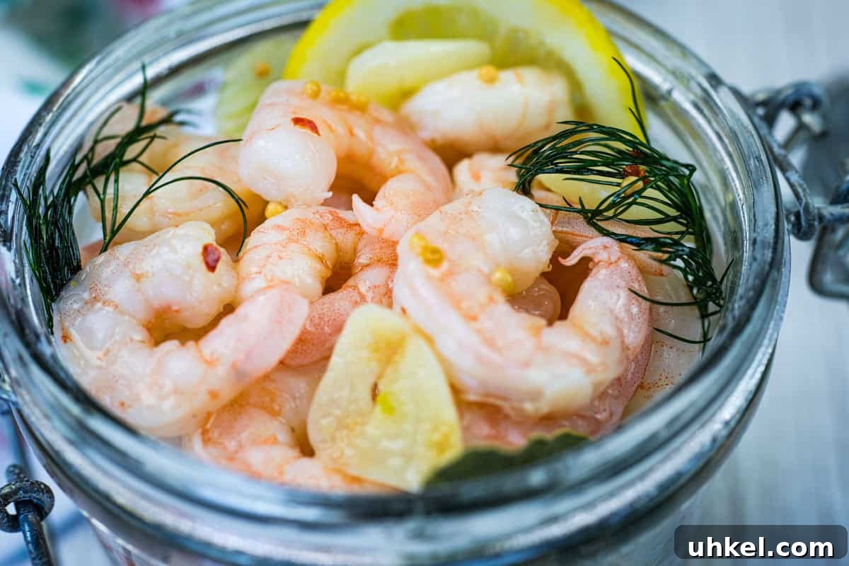 35 Timeless Southern Recipes That Always Delight 9 Close-up Southern Style Pickled Shrimp with lemon slices and dill on a jar.
