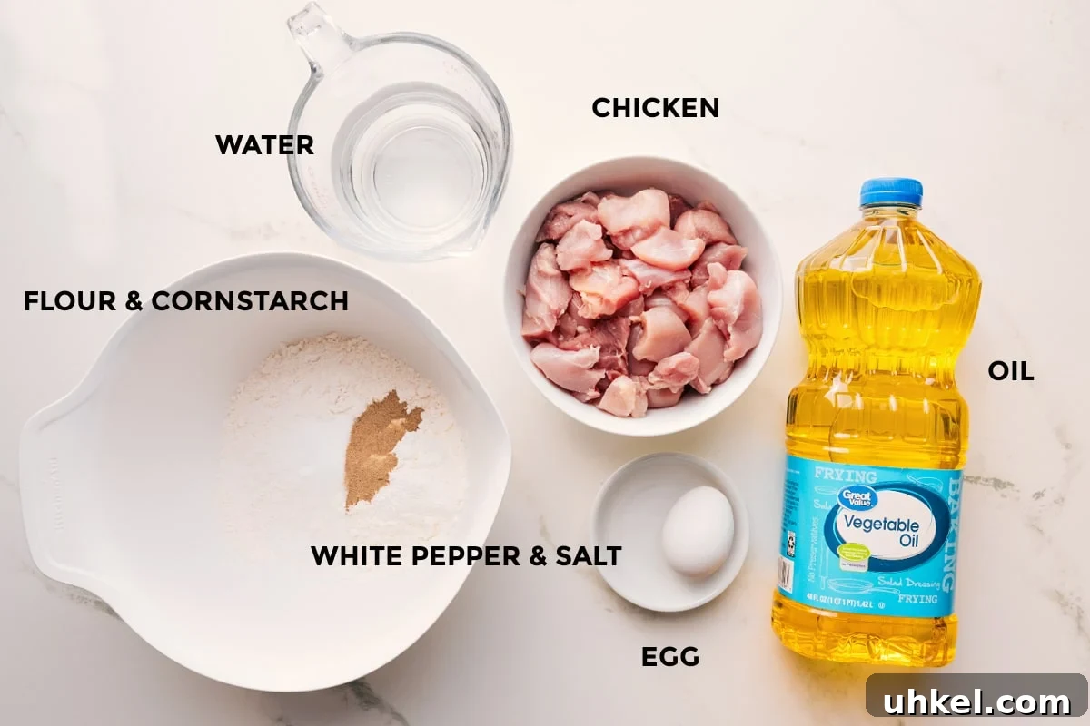 Korean Chicken Recipe Ingredients Needed Korean chicken recipe ingredients prepped out for easy assembly including the flour, cornstarch, water, chicken, white pepper, salt, egg, and oil.