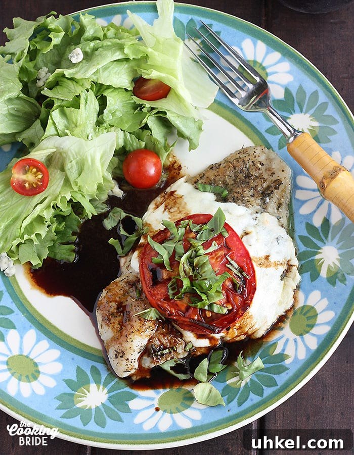 Caprese-Style Baked Catfish Fillets: Tomato, Basil & Mozzarella 8 Caprese baked catfish fillet and a simple salad on a blue and green floral plate with a fork on the side