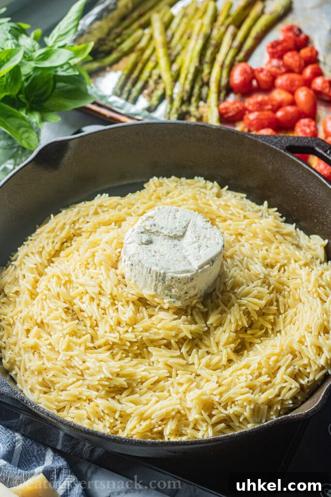 Creamy Orzo with Oven-Roasted Asparagus and Parmesan 4 Cooked orzo in a pan with boursin cheese on top.